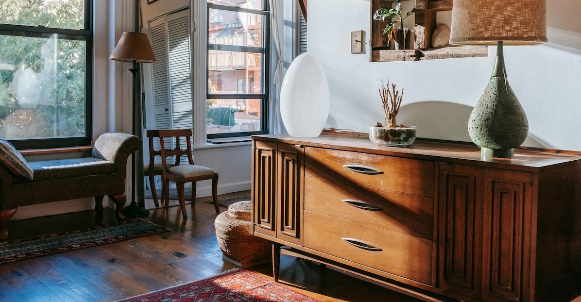 A stylish, sunlit room with a vintage wooden sideboard and other pre-loved furniture.